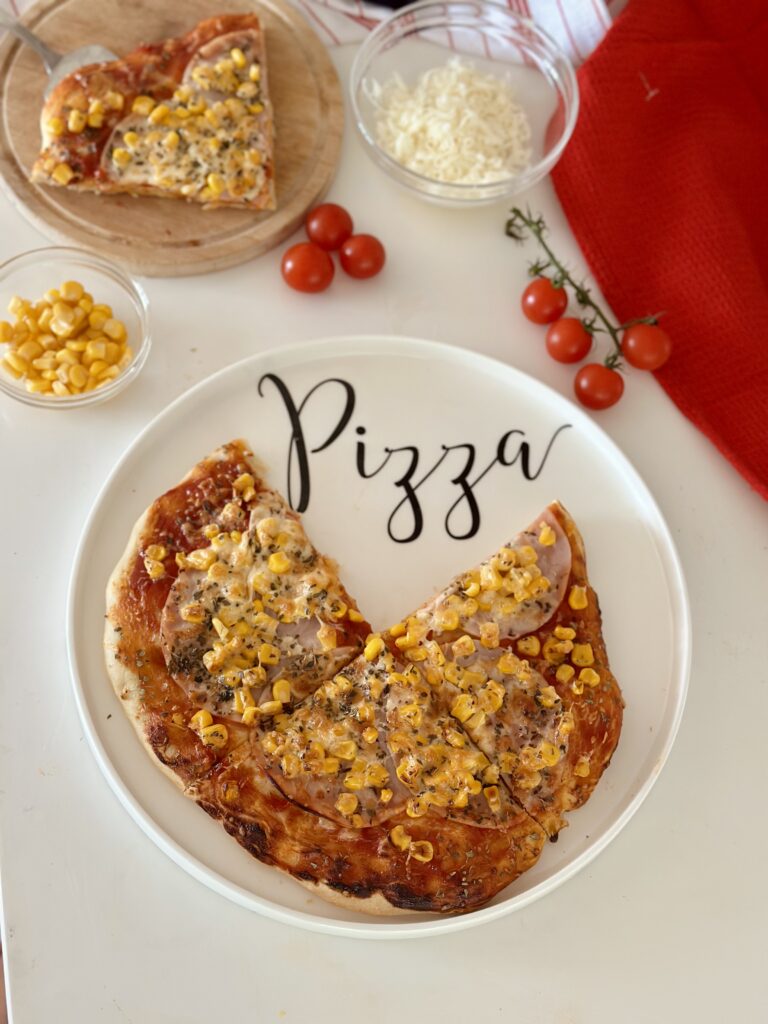 Házi sonkás-kukoricás pizza szeletekre vágva, puha tésztával