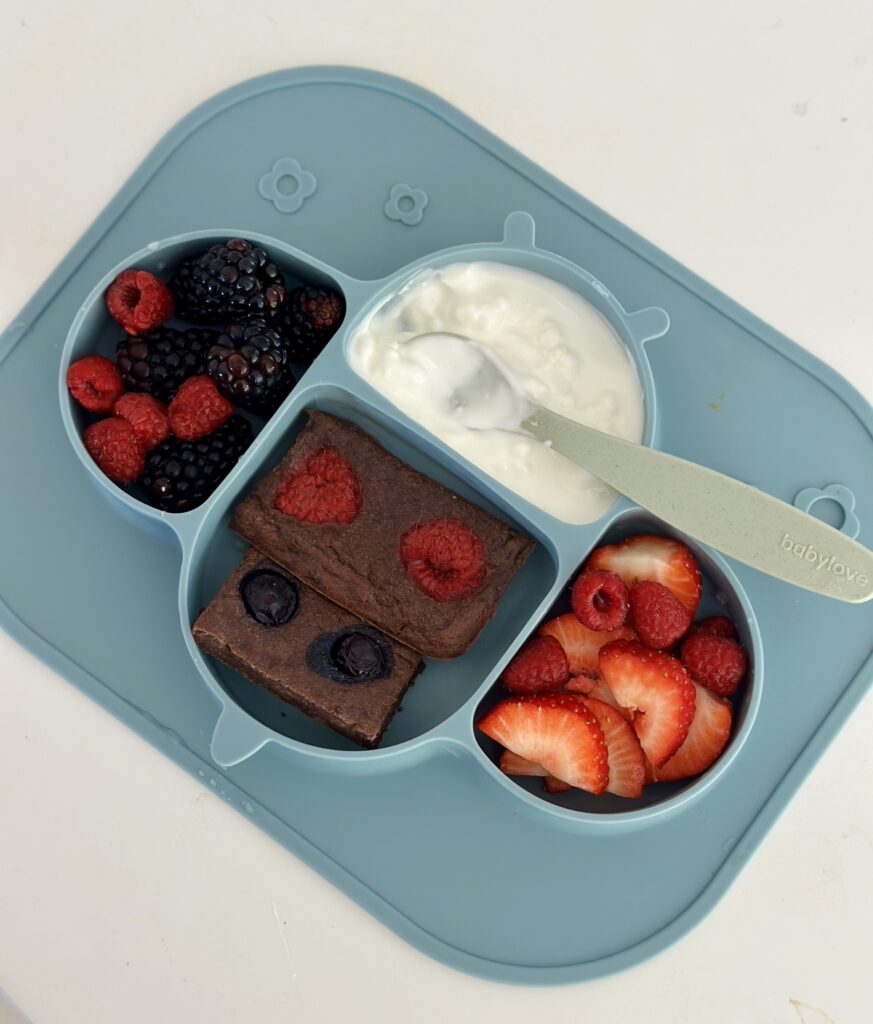 Cukormentes brownie kockák osztott szilikon babatányéron joghurttal, eperrel, málnával és szederrel